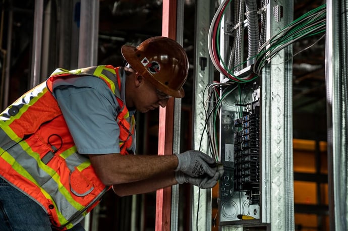Electrician working on wiring, gaining hands-on experience through Power Design's apprenticeship training program.