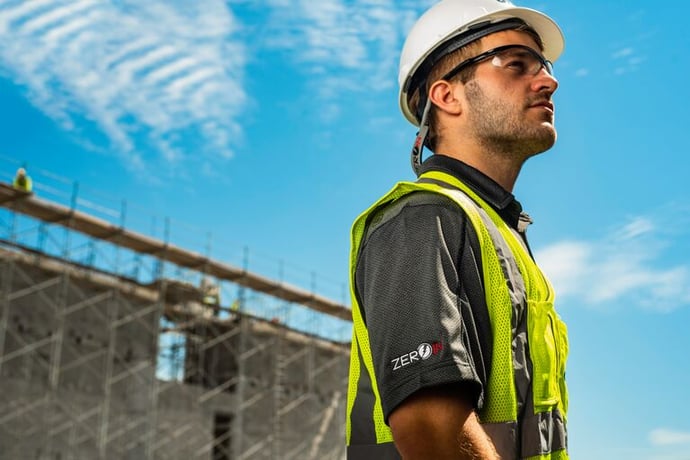 Construction worker surveying the job site to ensure adherence to safety and quality standards.
